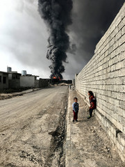Sebastiano Tomada – Grand Prize Winner, Φωτογράφος της Χρονιάς (iPhone 6s), «Τα παιδιά του Qayyarah»

Ο ίδιος αναφέρει: «Tα παιδιά περιπλανιούνται στους δρόμους του Qayyarah κοντά σε μια εστία φωτιάς που έχει ξεσπάσει σε μια πετρελαιοπηγή η οποία έχει πυρποληθεί από μαχητές του ISIS»