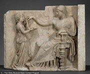 Οι ιστορικοί πάντως δεν έχουν καμία αμφιβολία ότι πρόκειται για την απεικόνιση νεκρής γυναίκας η οποία αγγίζει την κοσμηματοθήκη καθώς οι αρχαίοι Έλληνες ήθελαν να πιστεύουν ότι οι νεκροί μπορούν να διατηρούν και μετά το θάνατο κάποιες από τις πολυτέλειες της ζωής και αυτό απεικονίζεται σε εκατοντάδες νεκρικές παραστάσεις.

